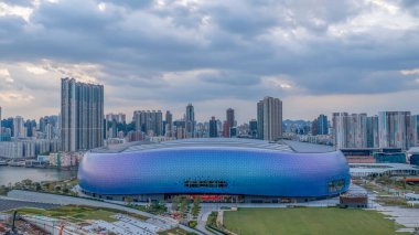 Modern stadyum Alacakaranlık Kowloon siluetinin altında aydınlandı