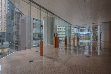 Parlak, çağdaş ofis lobisinde ahşap oyulmuş heykelcikler var.