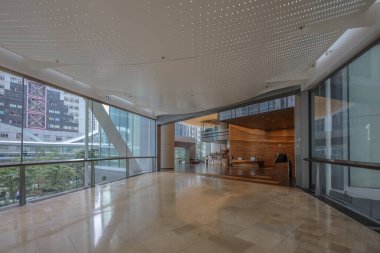 Cam duvarlı yürüyüş yolu ve metal çerçeve kemeri olan gökdelen,