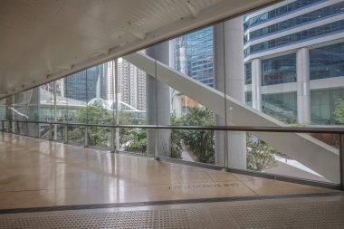 Çağdaş bir ofis binasının içinde camdan duvarlar olan kapalı bir koridor.