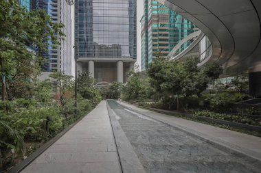 Cam kulelerle çerçevelenmiş modern bir şehir meydanı, parlak bir su kanalı.,