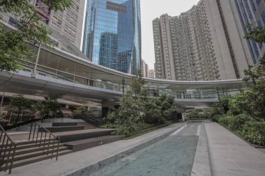 Cam kulelerle çerçevelenmiş modern bir şehir meydanı, parlak bir su kanalı.,