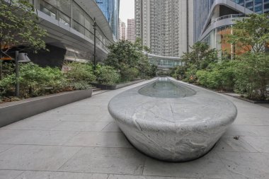 Cam kulelerle çerçevelenmiş modern bir şehir meydanı, parlak bir su kanalı.,