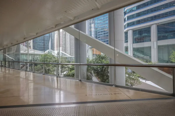 Çağdaş bir ofis binasının içinde camdan duvarlar olan kapalı bir koridor.