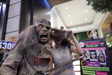 Ürkütücü karakter gece hayatı kutlamalarında kalabalığa katılıyor.