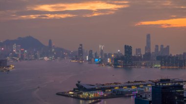 Alacakaranlıkta parlayan ışıklarla Hong Kong şehri manzarası