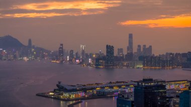 Alacakaranlıkta parlayan ışıklarla Hong Kong şehri manzarası