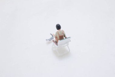 Küçük bir kukla yeşil bir sandalyede otururken küçük bir kukla