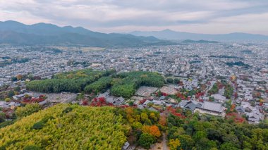 Şehir silüeti tapınakları harmanlıyor doğa tepeleri 24 Kasım 2025