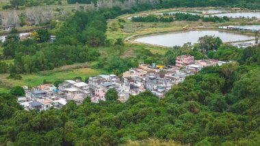 20 Aralık 2025 'te yeşil tarım alanlarının arasına yerleşmiş kırsal köy manzarası