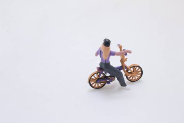 A small plastic figurine of a person riding a purple motorcycle