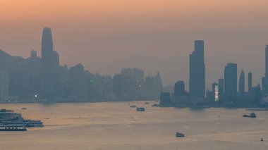 Hong Kong limanı ve ufuk çizgisi üzerinde sıcak gün batımı ışığı 4 Ocak 2026