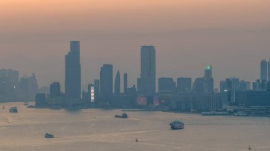 Hong Kong limanı ve ufuk çizgisi üzerinde sıcak gün batımı ışığı 4 Ocak 2026