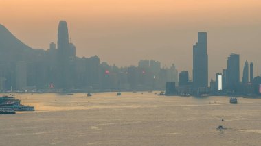 Hong Kong limanı ve ufuk çizgisi üzerinde sıcak gün batımı ışığı 4 Ocak 2026