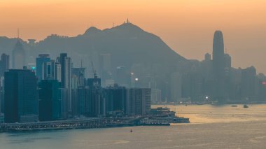 Hong Kong limanı ve ufuk çizgisi üzerinde sıcak gün batımı ışığı 4 Ocak 2026