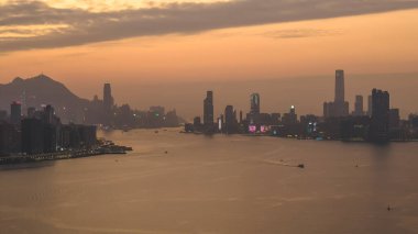 Hong Kong limanı ve ufuk çizgisi üzerinde sıcak gün batımı ışığı 4 Ocak 2026