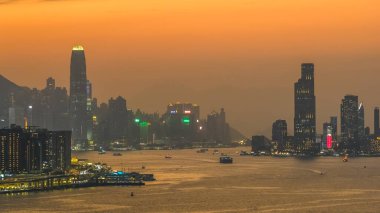 Hong Kong limanı ve ufuk çizgisi üzerinde sıcak gün batımı ışığı 4 Ocak 2026