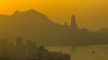 Hong Kong limanı ve ufuk çizgisi üzerinde sıcak gün batımı ışığı 4 Ocak 2026