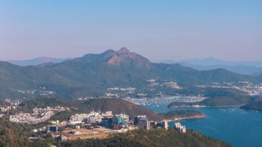 Karşısında cam ve beton kuleler bulunan yamaç manzaralı bir şehir, Ocak 11 2026