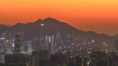 Şehir ışıkları akşam alacakaranlığı sırasında dağların altında parıldıyor. 11 Ocak 2026