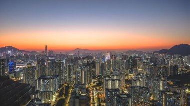 Sıcak akşam renkleri Kowloon binalarının merkezini ve 11 Ocak 2026 'yı vurguluyor.