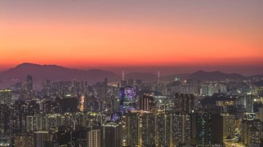 Sıcak akşam renkleri Kowloon binalarının merkezini ve 11 Ocak 2026 'yı vurguluyor.