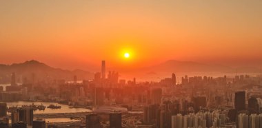 Sıcak günbatımı renkleri Kowloon silueti boyunca dramatik bir ışık saçıyor 11 Ocak 2026
