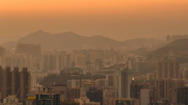 Sıcak akşam renkleri Kowloon binalarının merkezini ve 11 Ocak 2026 'yı vurguluyor.