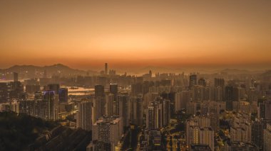 Yumuşak, parlak günbatımı renkleri Kowloon binalarını ve 11 Ocak 2026 'yı aydınlatır.