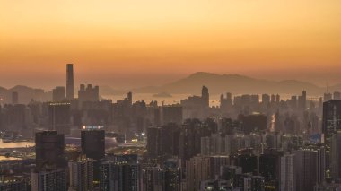 Şehir kuleleri ve dağların gölgesi parlayan gökyüzüne karşı 11 Ocak 2026