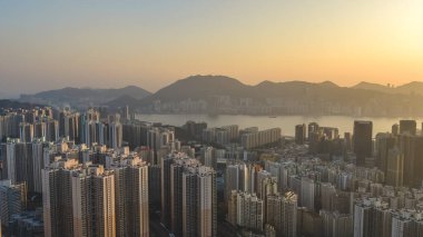 Yumuşak akşam parıltısı Kwun Tong binalarını ve 18 Ocak 2026 'yı aydınlatıyor.