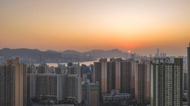 Parlayan gökyüzü Hong Kong binalarını ve uzak dağları vurguluyor 18 Ocak 2026