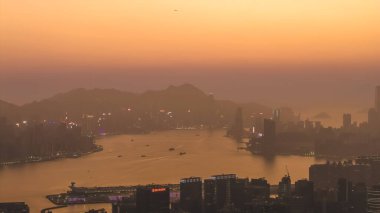 18 Ocak 2026 'da sisli Hong Kong ufuk çizgisinde ılık, parlayan güneş batıyor.