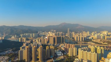 Güneş ışığı 10 Ocak 2026 'da yüksek binalar, nehir ve dağ zeminini vurguluyor