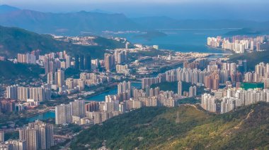 Çevresindeki yeşil dağların altındaki vadi boyunca uzanan şehir silüeti, 25 Ocak 2026