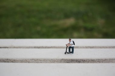 Büyük Beyaz Adımlarda Scooter süren bir figür.