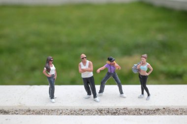 Minik model karakterler parlak açık yüzey boyunca güvenle poz verirler