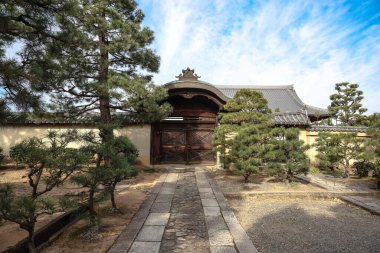 Tarihi ahşap kapı huzurlu Kyoto tapınağının avlusuna açılıyor