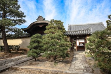 Tarihi ahşap kapı huzurlu Kyoto tapınağının avlusuna açılıyor