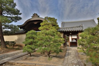 Tarihi ahşap kapı huzurlu Kyoto tapınağının avlusuna açılıyor