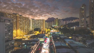 Akşam ışıkları 5 Şubat 2026 'da şehir arkaplanına karşı köy pazarını aydınlatacak