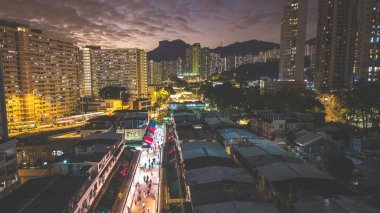 Akşam ışıkları 5 Şubat 2026 'da şehir arkaplanına karşı köy pazarını aydınlatacak