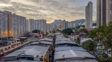 Tarihsel köy çatıları, 5 Şubat 2026 'da günbatımında modern kulelere tezat oluşturuyor.