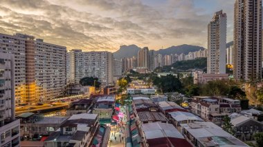 Tarihsel köy çatıları, 5 Şubat 2026 'da günbatımında modern kulelere tezat oluşturuyor.