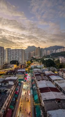 Tarihsel köy çatıları, 5 Şubat 2026 'da günbatımında modern kulelere tezat oluşturuyor.