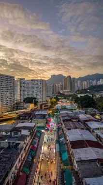 Tarihsel köy çatıları, 5 Şubat 2026 'da günbatımında modern kulelere tezat oluşturuyor.