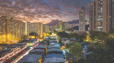 Akşam ışıkları 5 Şubat 2026 'da şehir arkaplanına karşı köy pazarını aydınlatacak