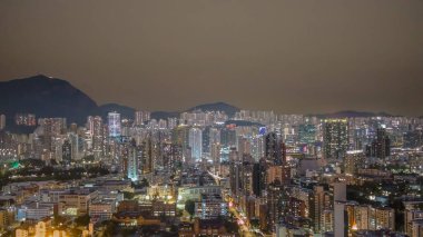 6 Şubat 2026 'da Kowloon caddelerinin üzerinde aydınlık kuleler yükseliyor.