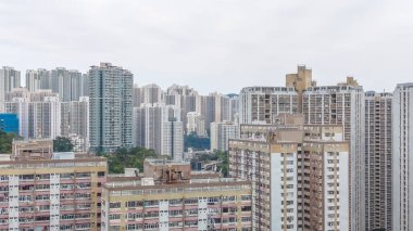 Kalabalık caddelerin ve yeşilliklerin üzerinde uzun apartmanlar yükseliyor. 8 Şubat 2026