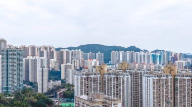 Kalabalık caddelerin ve yeşilliklerin üzerinde uzun apartmanlar yükseliyor. 8 Şubat 2026